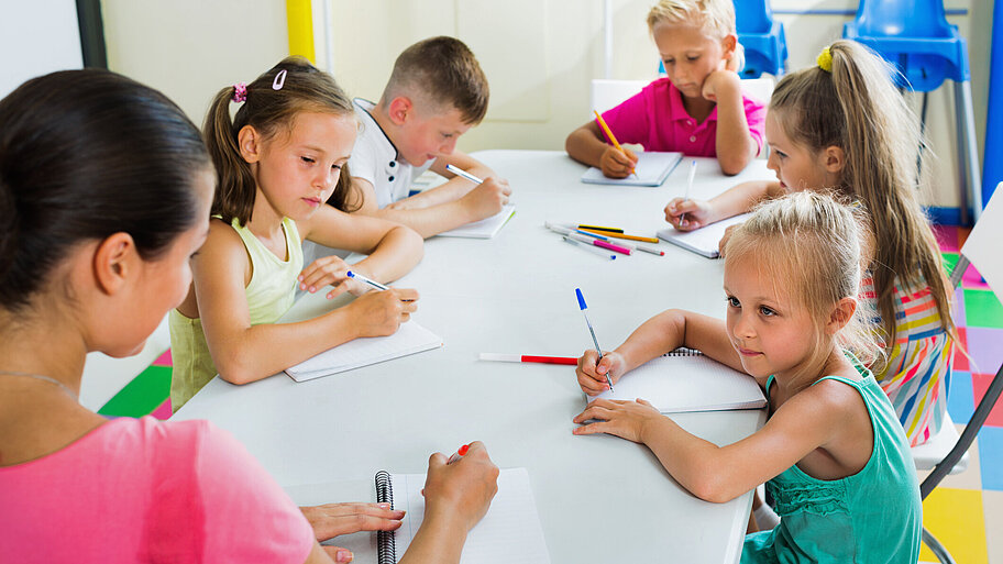 Kinder schreiben gemeinsam im Grundschulunterricht