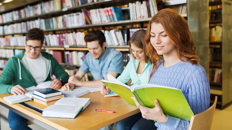 Junge Menschen, die zusammen in einer Bibliothek lernen