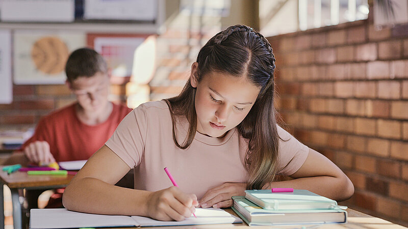 Mädchen schreibend während eines Tests im Klassenzimmer