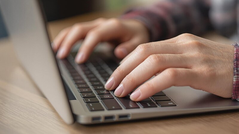 Hände auf einer Laptoptastatur