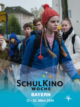 Schulkinder im Hintergrund, gehendes Mädchen mit roter Mütze und blauer Jacke vorne