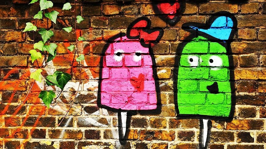 Graffittibild von zwei bunten Figuren mit Herz