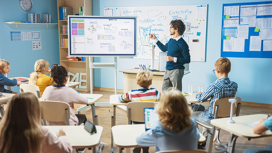 Lehrer unterrichtet Schüler an interaktivem digitalen Whiteboard