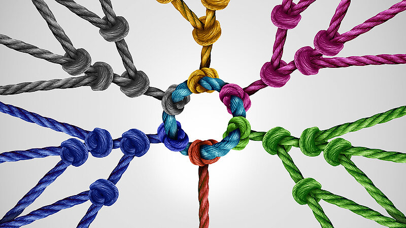 Miteinander verbundene Seile unterschiedlicher Farben als Metapher für soziale Verbindung