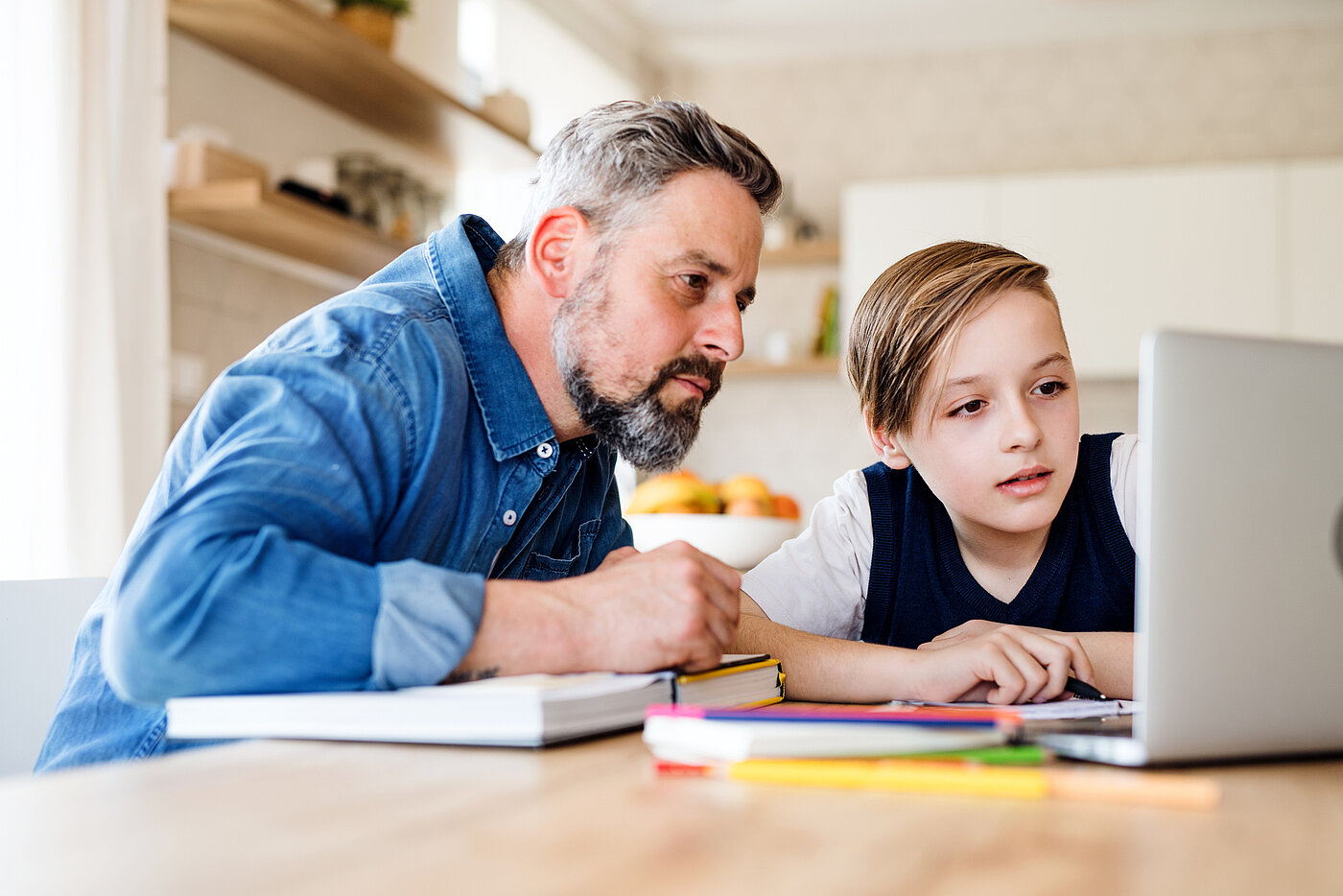 Vater und Sohn lernen gemeinsam vor dem Laptop