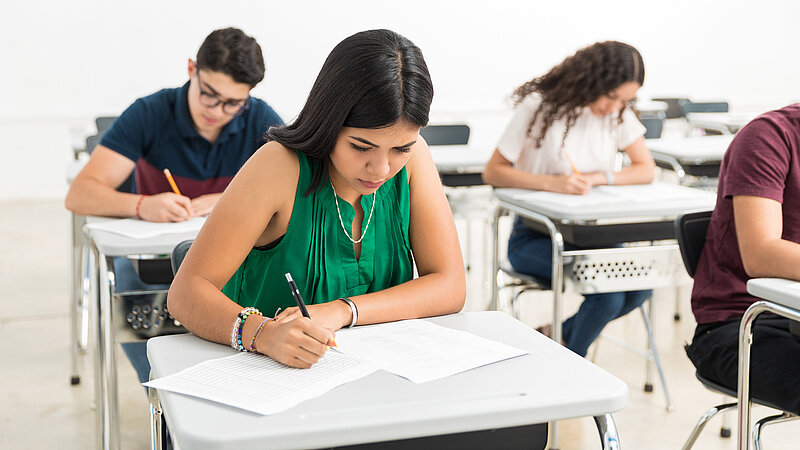 Schülerinnen und Schüler schreiben Prüfung im Klassenzimmer