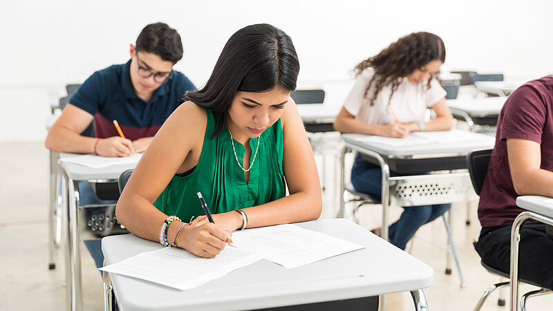 Schülerinnen und Schüler schreiben Prüfung im Klassenzimmer