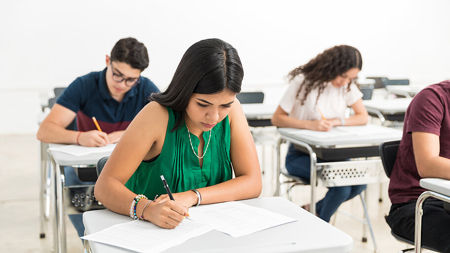 Schülerinnen und Schüler schreiben Prüfung im Klassenzimmer