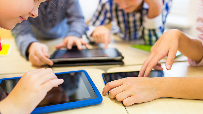close up of school kids playing with tablet pc