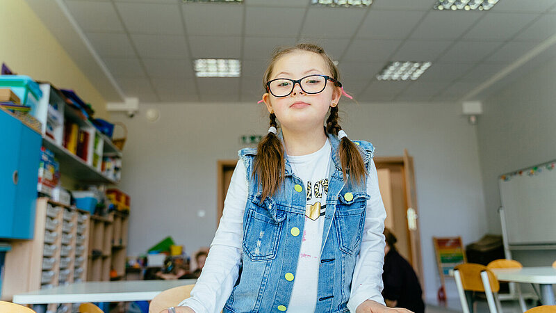 glückliche Schülerin mit Down-Syndrom am ersten Schultag