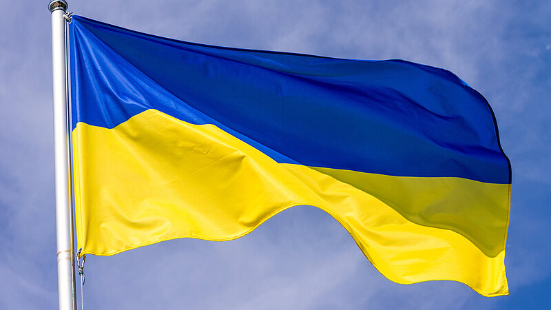 Flagge der Ukraine weht über blauem Himmel