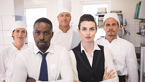 Gruppe Erwachsener im Gastgewerbe in Arbeitskleidung