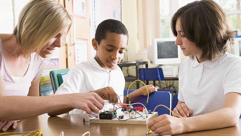 Schüler und Schüler experimentieren mit Strom