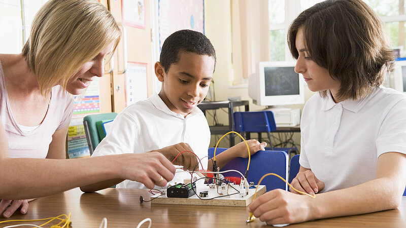 Schüler und Schüler experimentieren mit Strom