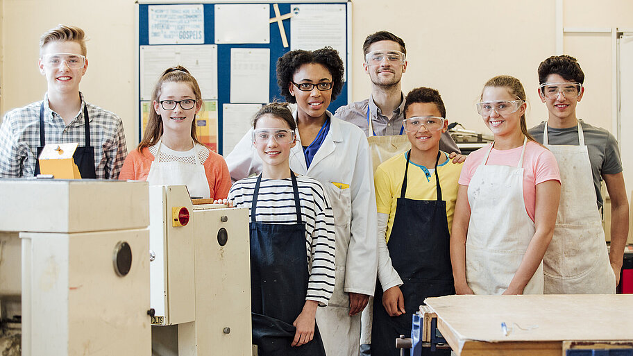 Schülerinnen und Schüler mit Schutzbrillen im Werkraum