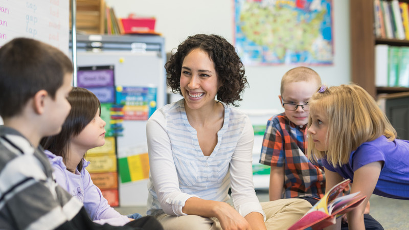 Frau liest Kindern im Klassenzimmer vor
