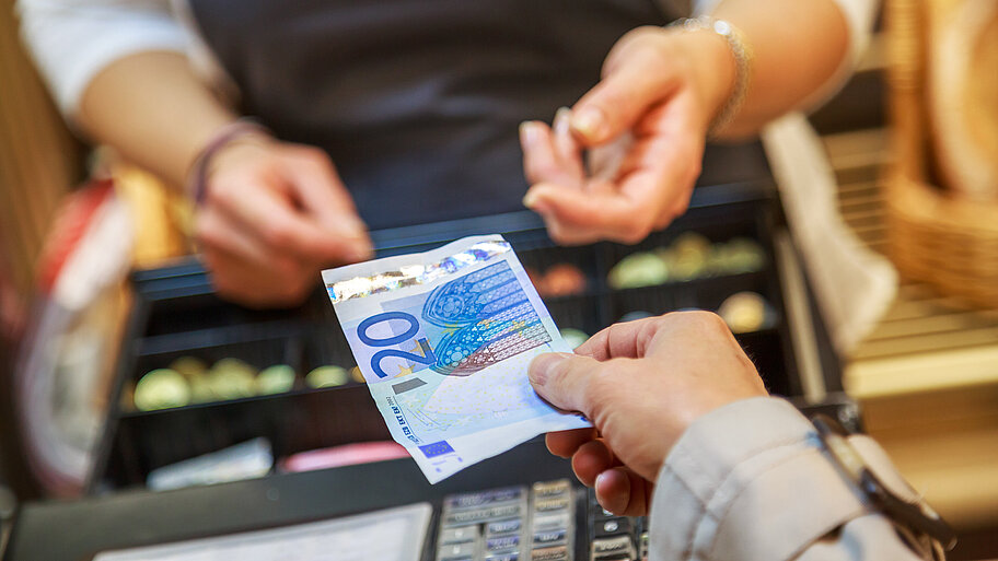 Frau zahlt an offener Ladenkasse mit 20-Euro-Banknote