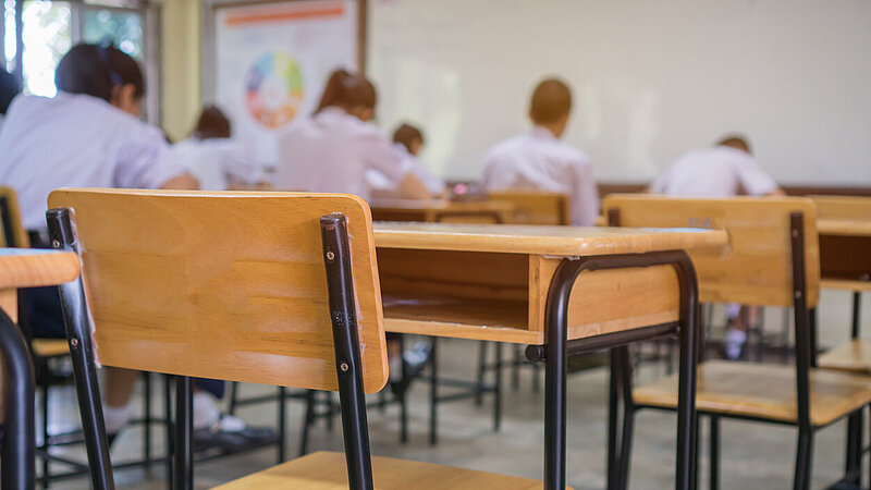 Klassenzimmer mit Schülern, die Prüfung schreiben. 