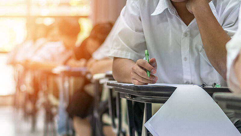 Junge Menschen bei schriftlicher Prüfung im Klassenraum