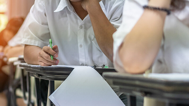 Junge Menschen bei schriftlicher Prüfung im Klassenraum