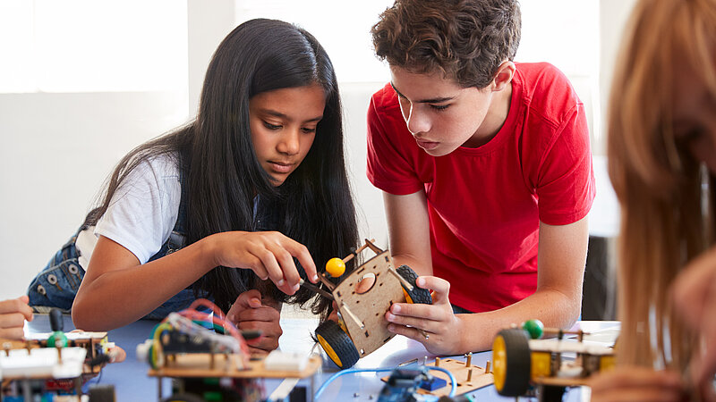 Schülerin und Schüler beim Experimentieren im Physikunterricht