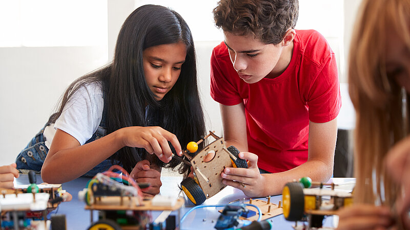 Schülerin und Schüler beim Experimentieren im Physikunterricht