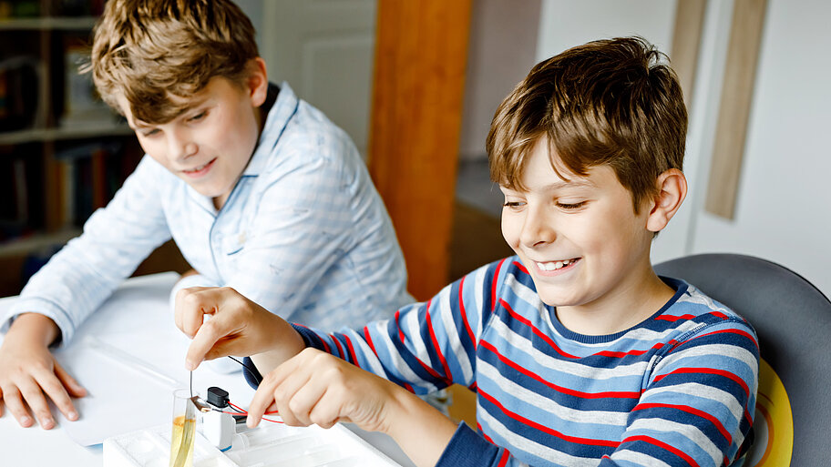 Zwei Schüler, die elektrische Experimente durchführen. 