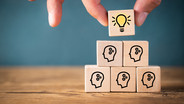 many people together having an idea symbolized by icons on cubes
