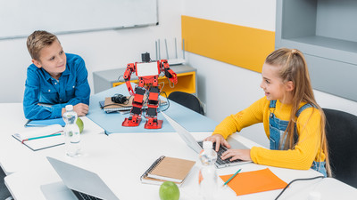 Schüler programmieren gemeinsam Roboter und nutzen Laptops im Unterricht