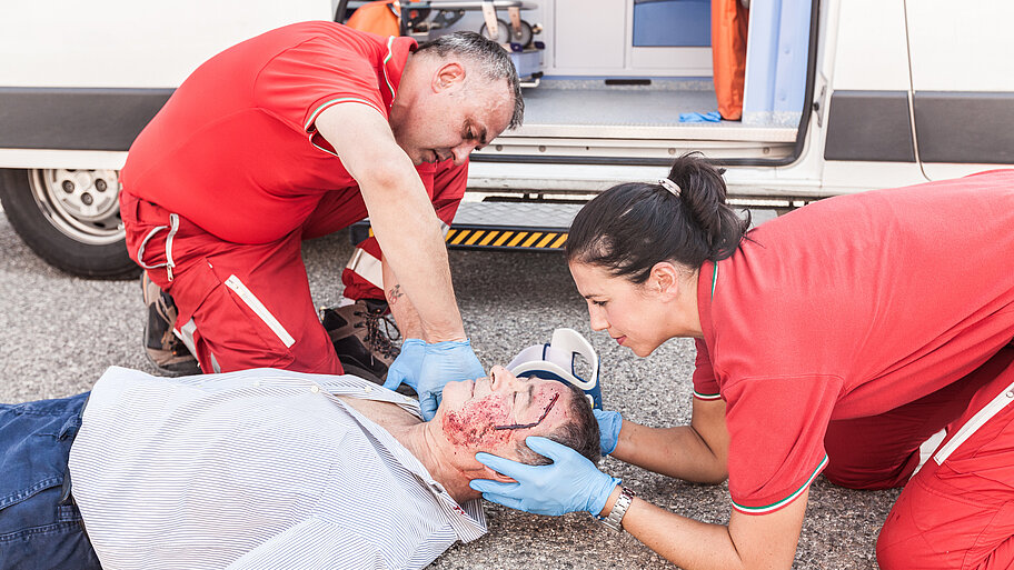 Rettungssanitäter leisten Erste Hilfe an verletztem Mann