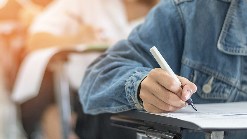 Nahaufnahme: Schriftliche Prüfung in der Schule mit schreibenden Schülern