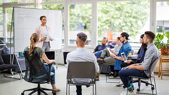 Teamarbeit: Junge Menschen im Stuhlkreis bei Präsentation