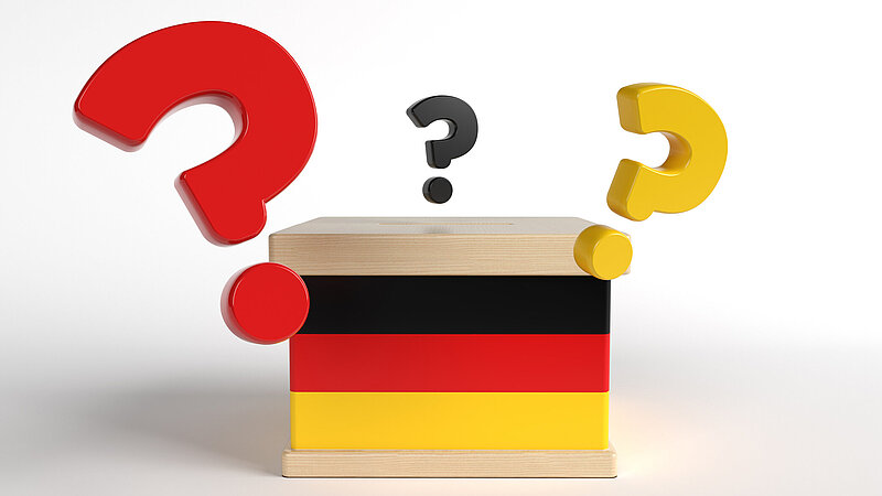 Wahlurne mit Deutschland-Flagge und Fragezeichen