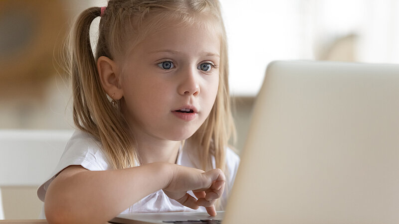 Junges Mädchen mit Laptop allein zu Hause