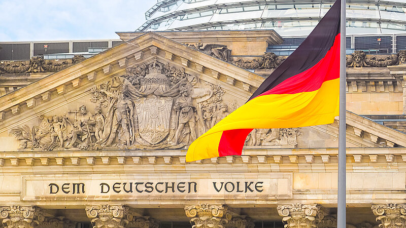 Deutsche Flagge weht vor dem Reichstagsgebäude in Berlin
