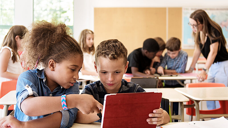 Schulkinder im Unterricht mit einem digitalen Tablet