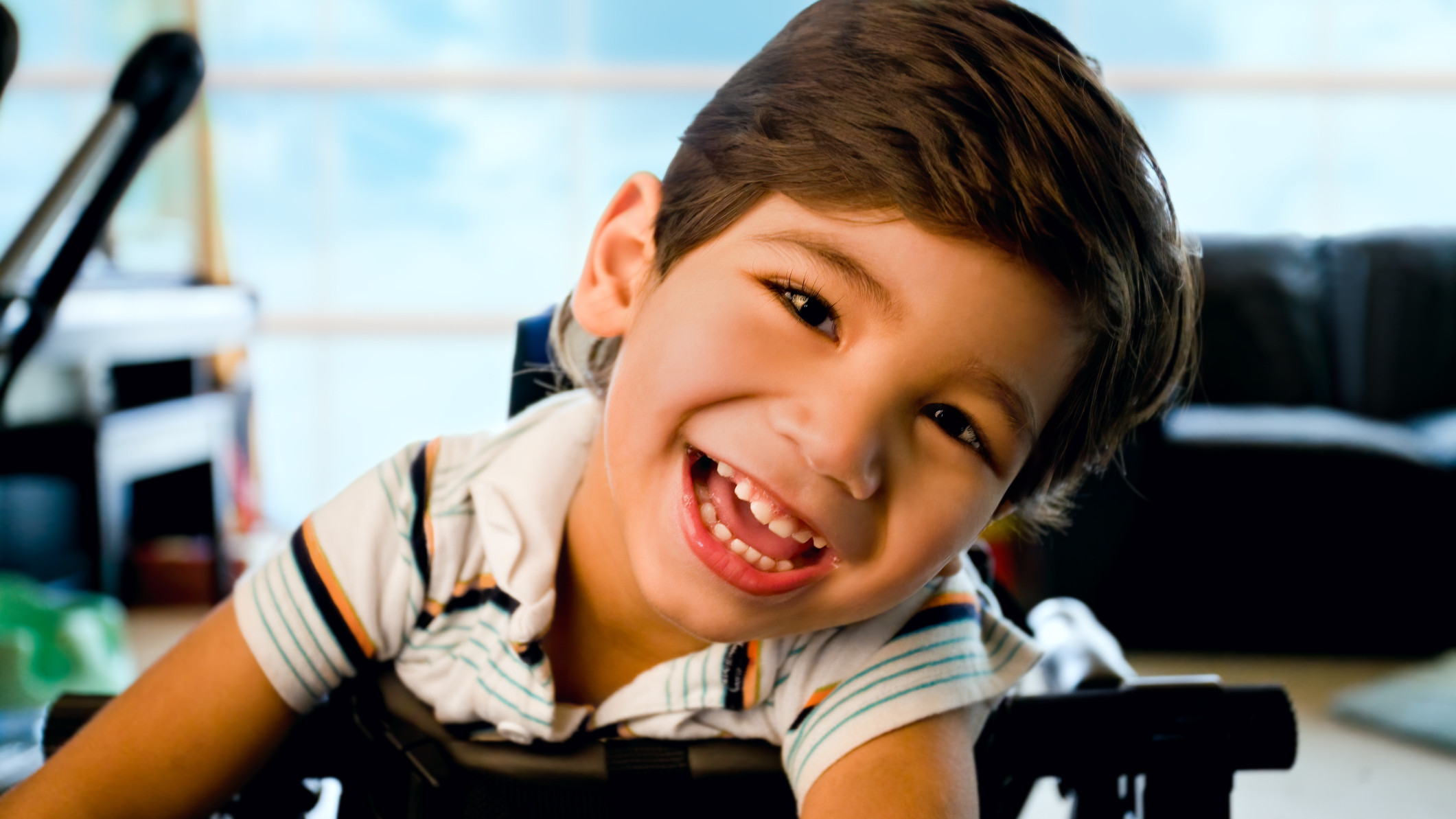 Happy smiling biracial disabled little boy standing in walker Happy smiling biracial disabled little boy standing in walker
