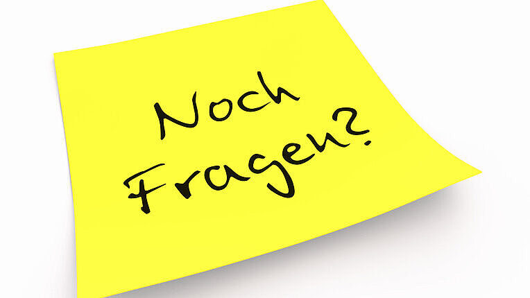 Notizzettel mit Aufschrift "Noch Fragen?"