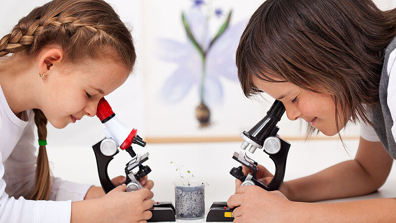 Zwei Schülerinnen arbeiten mit Mikroskope