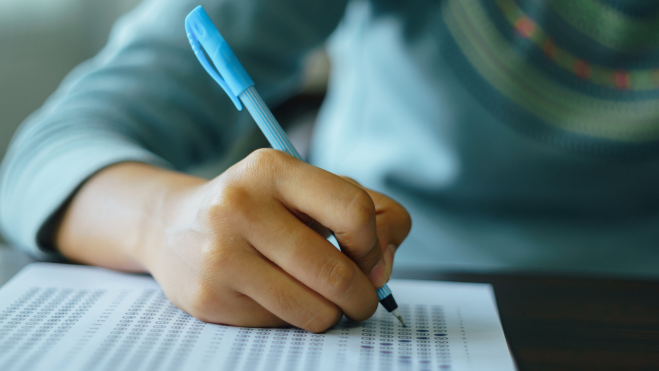 Nahaufnahme: Junge Hand, die etwas schreibt bzw. Prüfung bearbeitet