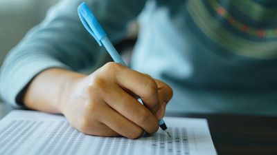 Nahaufnahme: Junge Hand, die etwas schreibt bzw. Prüfung bearbeitet