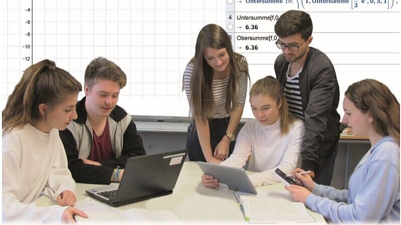Schülerinnen und Schüler schauen auf Laptops und Smartphone