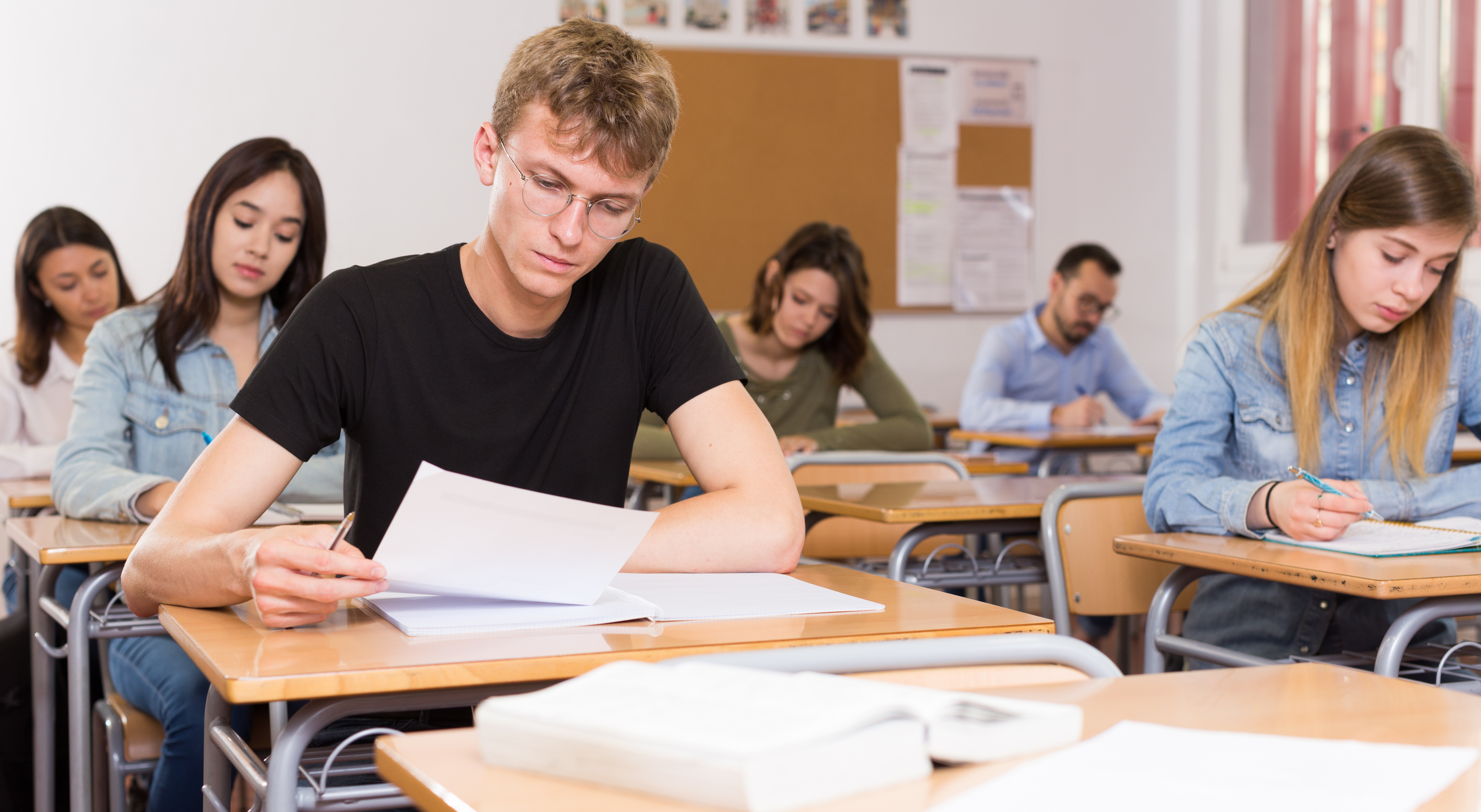 Junger Mann schreibt Test im Klassenzimmer